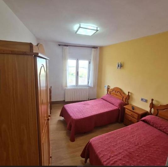 1 dormitorio con 2 camas y ventana en Hospedería municipal la cultural en Saucelle