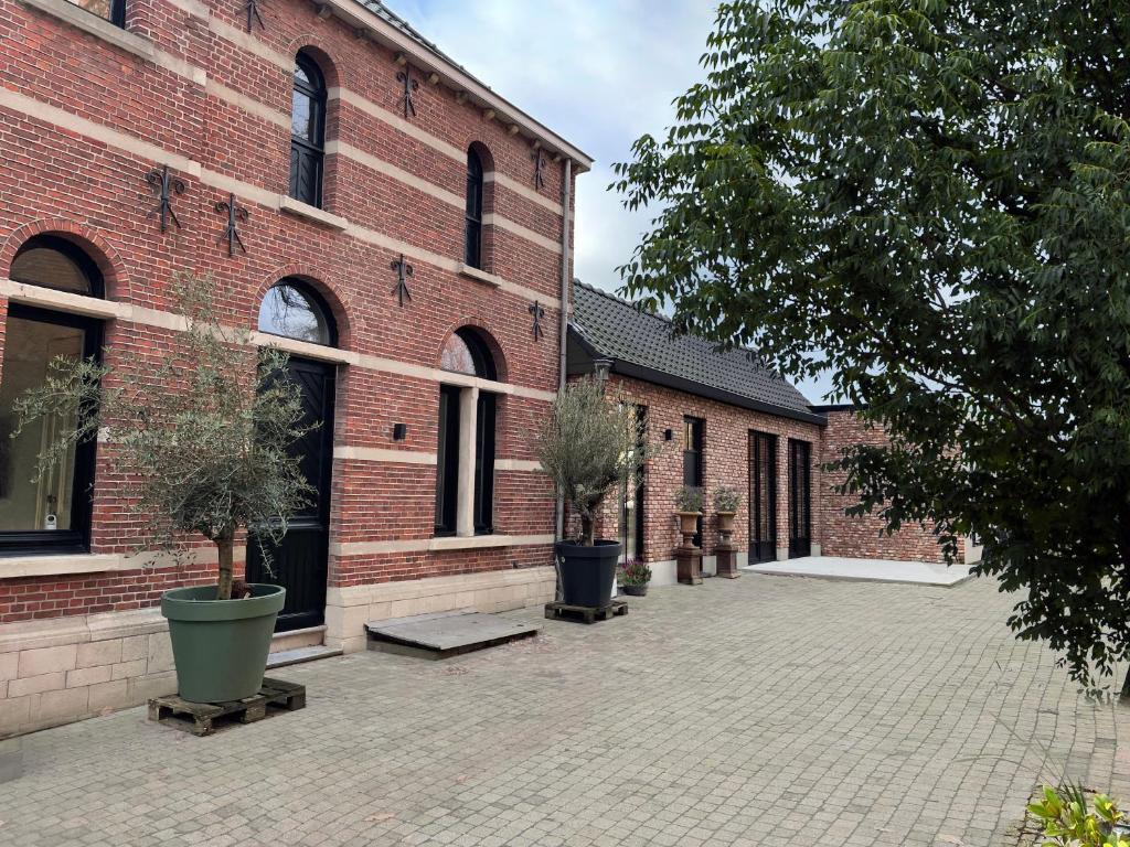 a brick building with potted trees in front of it at De Wilden Ezel in Mol