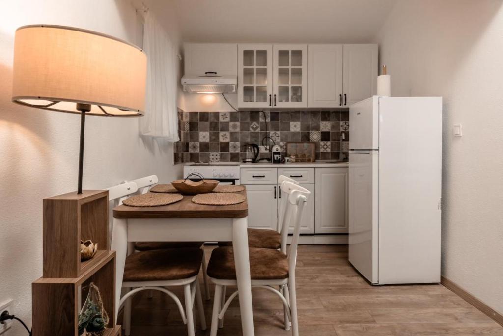 a small kitchen with a table and a refrigerator at Olive Grove in Bar