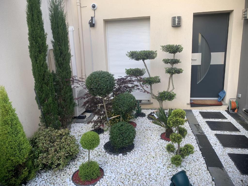 a garden with trees and plants in front of a building at Maison lumineuse à Torcy in Torcy