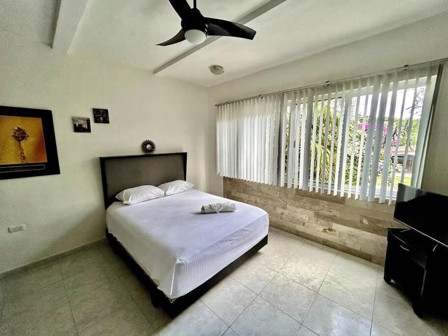 Schlafzimmer mit einem Bett und einem Deckenventilator in der Unterkunft Fantastico Duplex Familiar con AC Wifi & Alberca #1 in Mérida