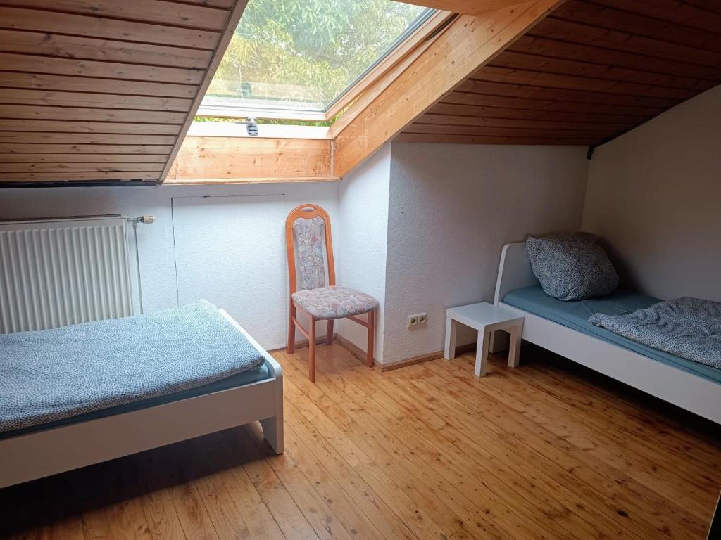 a small room with two beds and a chair at L8 Street Apartments - Renningen in Renningen