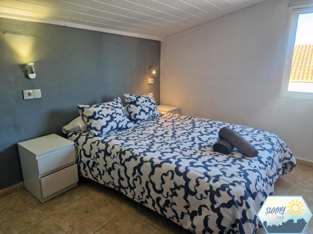 a bedroom with a bed with a blue and white comforter at Sunny Churriana Airport III in Málaga