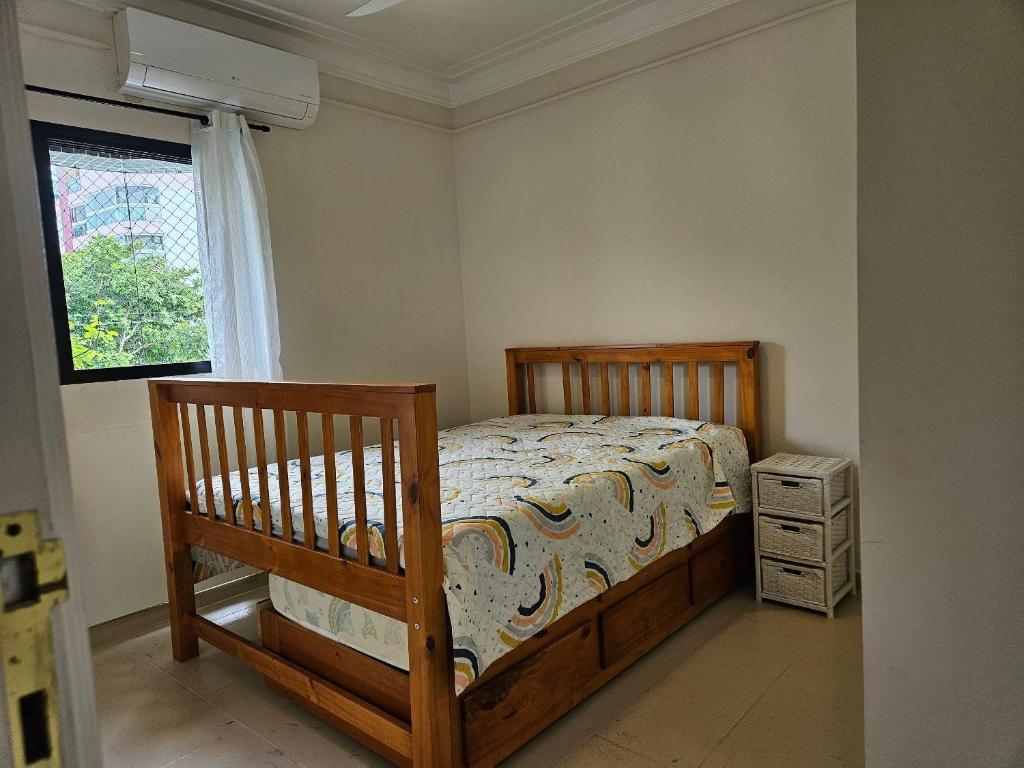 a bedroom with a wooden bed and a window at bwelcome - aconchego pé na areia mod 2 in Bertioga
