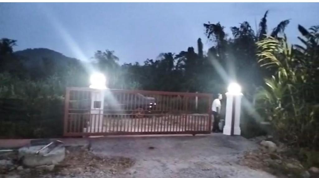 a man standing in front of a house with lights at home stay harith & humaira in Lengging