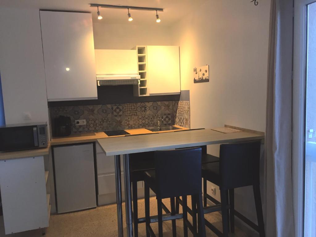 eine Küche mit einem Tisch mit Stühlen und einem Spiegel in der Unterkunft T2 relax in Six-Fours-les-Plages