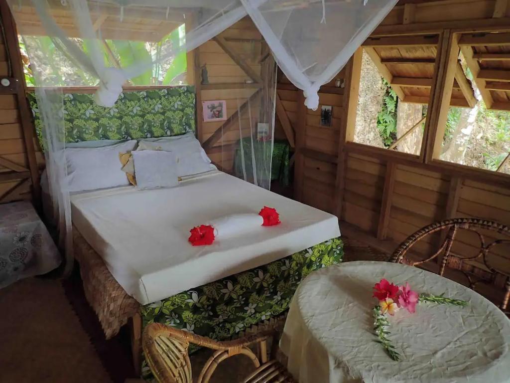 a bedroom with a bed with red flowers on it at Comfortable bungalow with a beautiful view in Munda