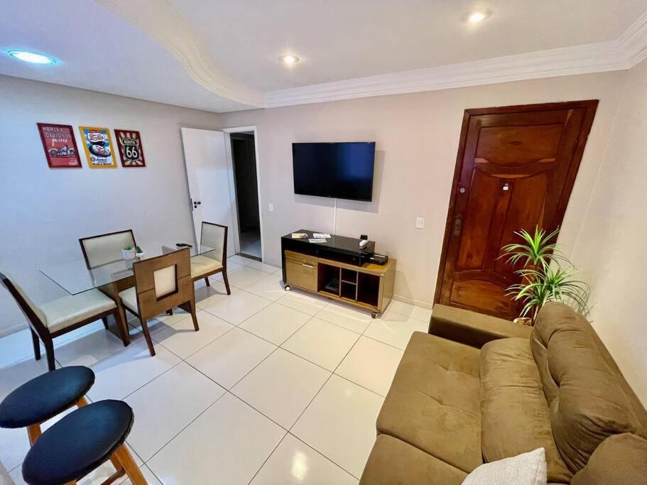 een woonkamer met een bank en een tafel bij 02 quadras do mar/ Espaçoso/chuveirão externo in Vitória