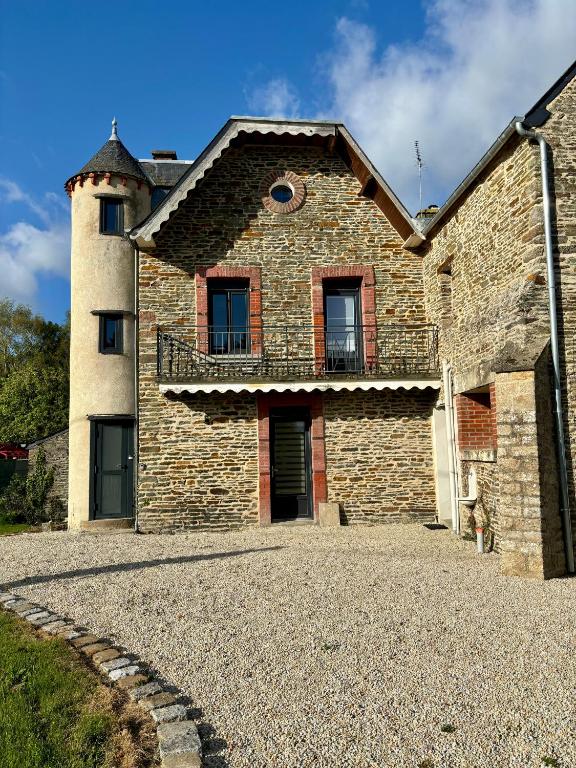 une ancienne maison en pierre avec un balcon dans un bâtiment dans l'établissement Gîte de la petite tour, à Pontorson
