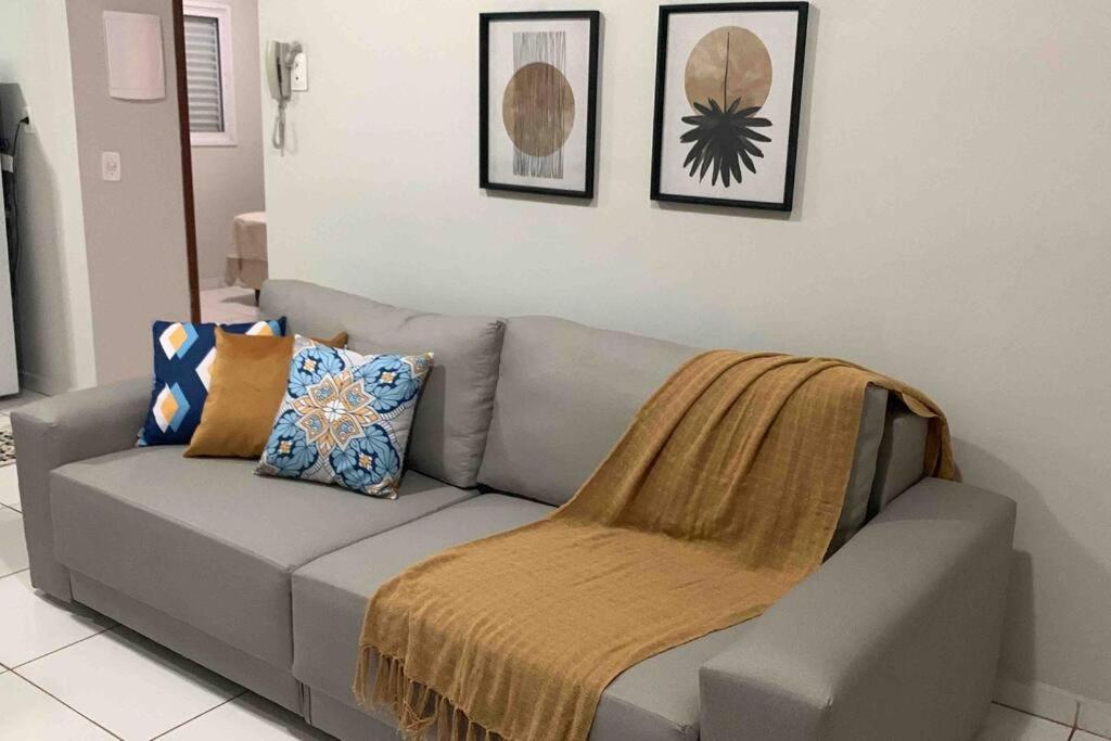 een bank met een deken in de woonkamer bij Apartamento Araguari com piscina in Araguari