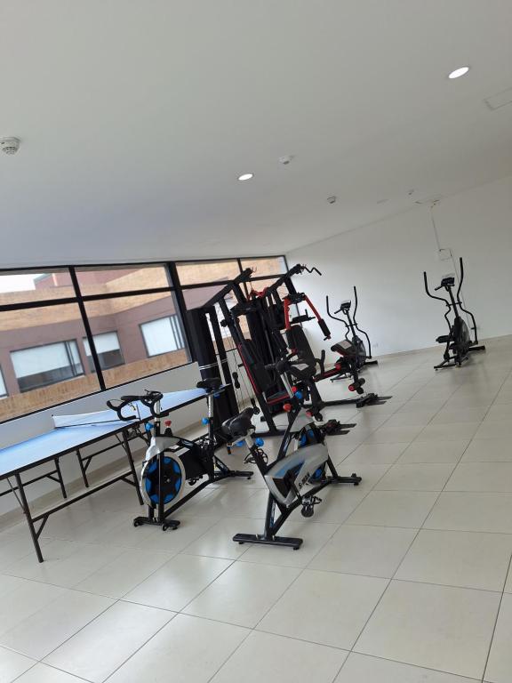 una fila de bicicletas estáticas en un gimnasio en Estudio en edificio con piscina climatizada, en Bogotá
