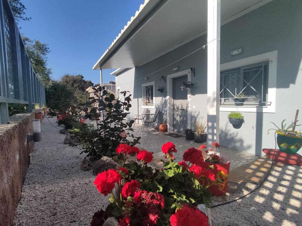 a house with red flowers on the side of it at Il Mio Riposo in Vasilikos