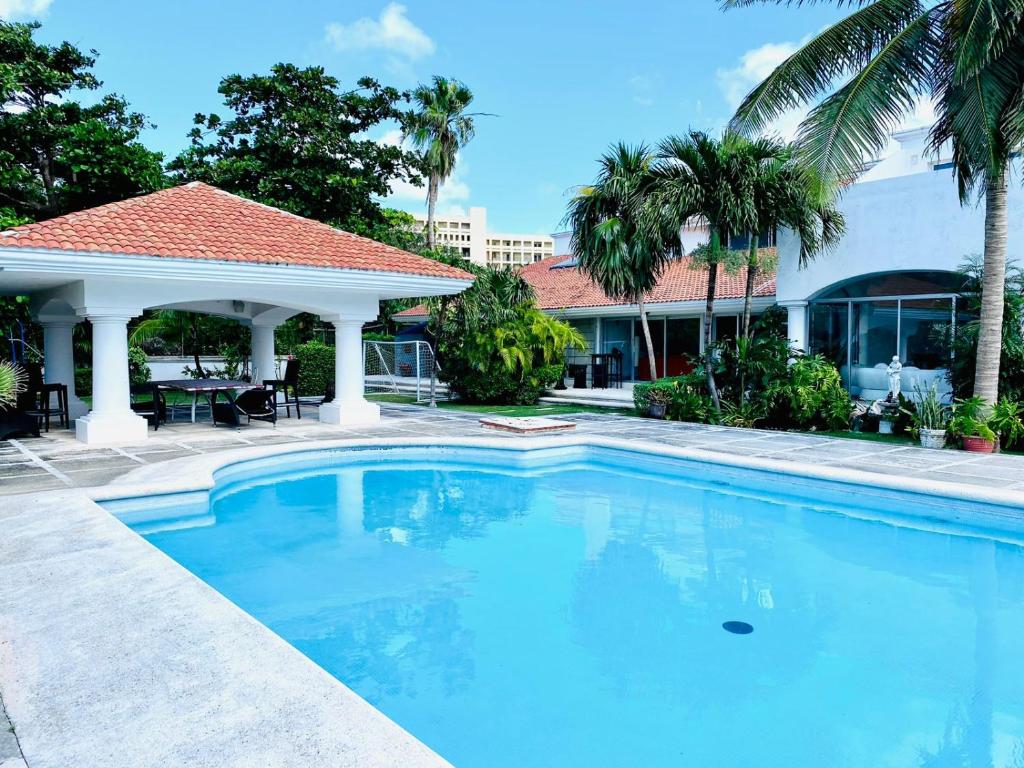 a large swimming pool in front of a house at CASA BLANCA in Cancún