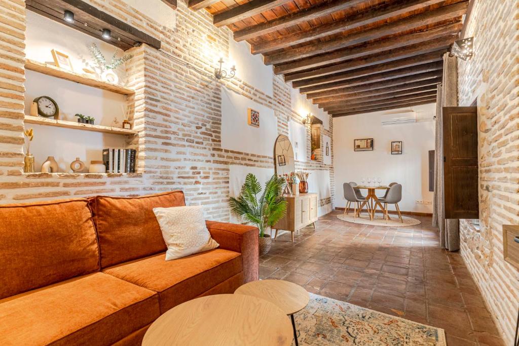 a living room with a couch and a brick wall at Apartamento San Bartolome Albaicin in Granada