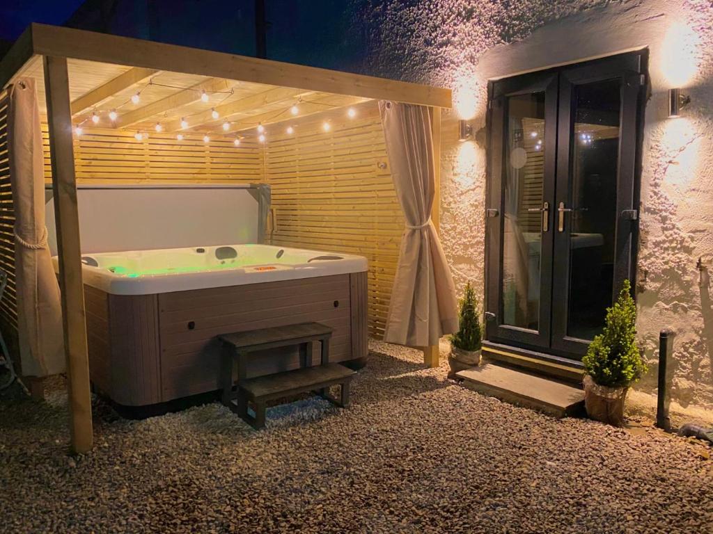 a bathroom with a tub and a shower with lights at Spa Garden Cottage - Upper Hopton in Mirfield