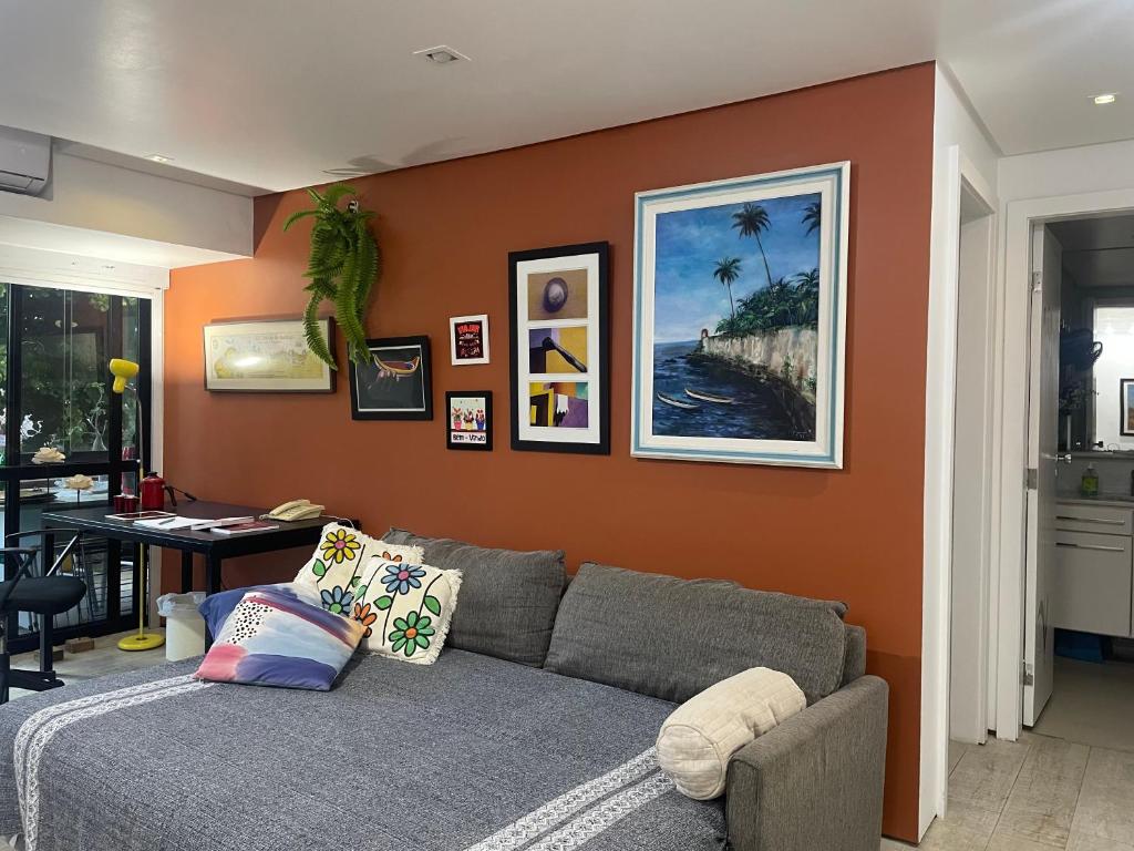 un soggiorno con divano grigio e parete arancione di Flat encantador no Atlantic Towers a Salvador