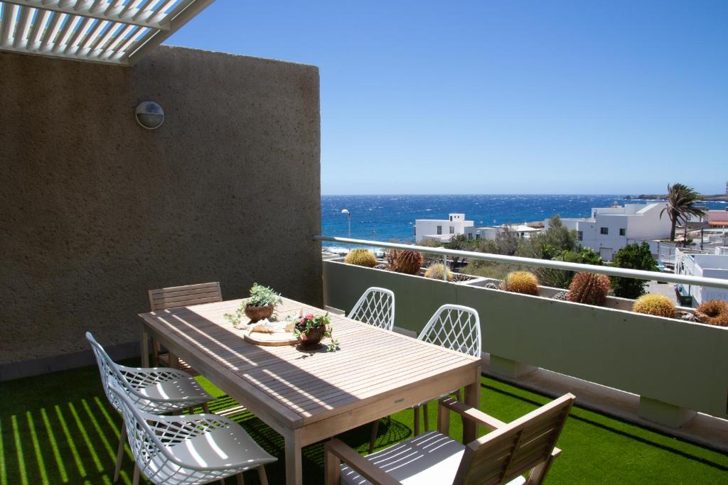 een tafel en stoelen op een balkon met uitzicht op de oceaan bij Sea View apartment 2B in Poris de Abona