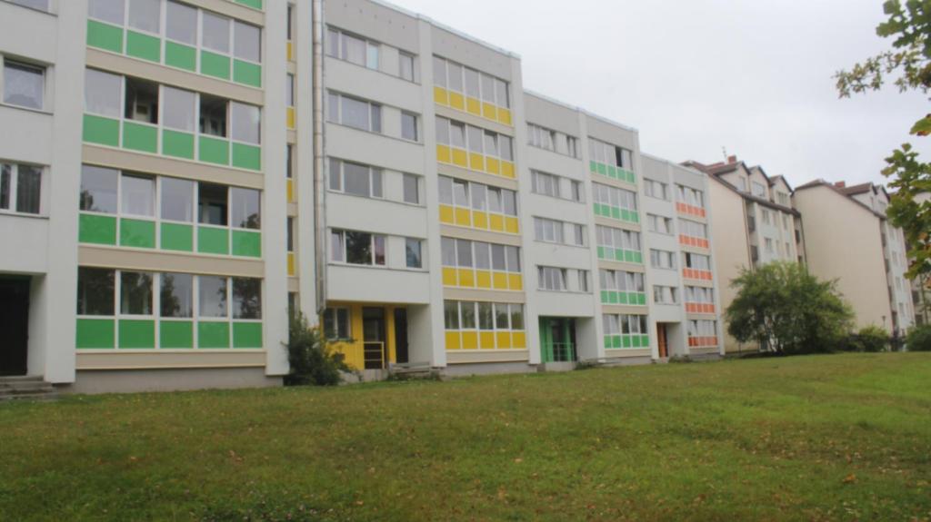 una fila de edificios con ventanas verdes y amarillas en Tomas Apartment, en Cēsis