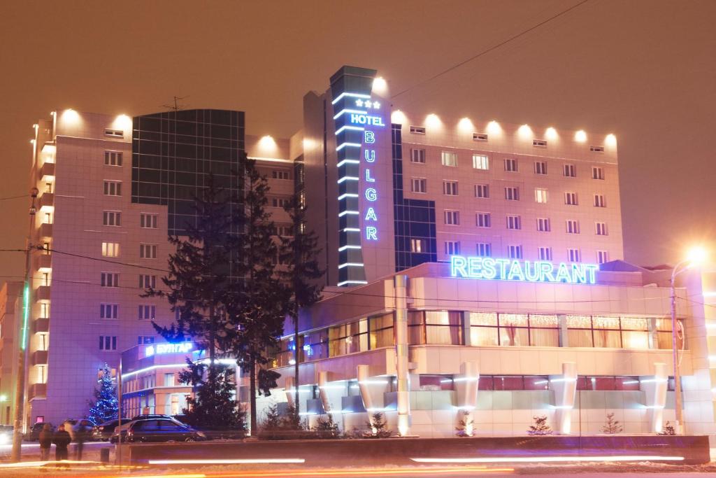 a hotel building with a sign on it at night at Bulgar Hotel in Kazan