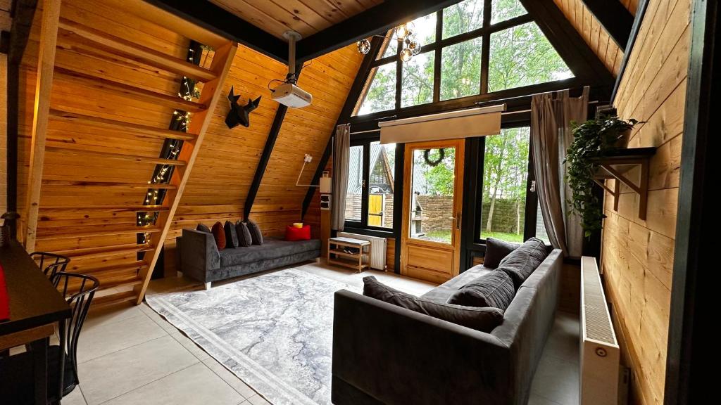 a living room of a log cabin with couches and windows at Pentalow Cabin in Kocaeli