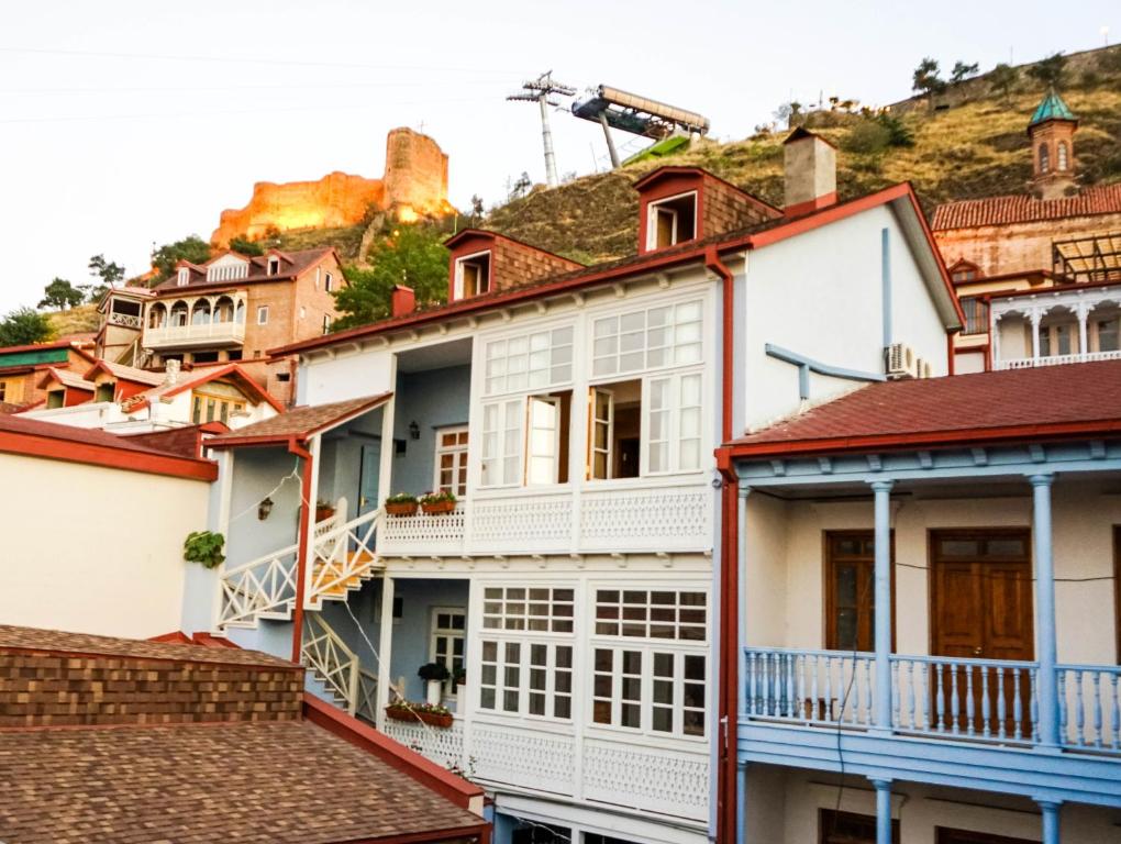 een groep huizen met een heuvel op de achtergrond bij Guest House Goari in Tbilisi City