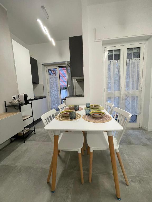 een eetkamer met een witte tafel en stoelen bij Maison Cristina in Lido di Ostia