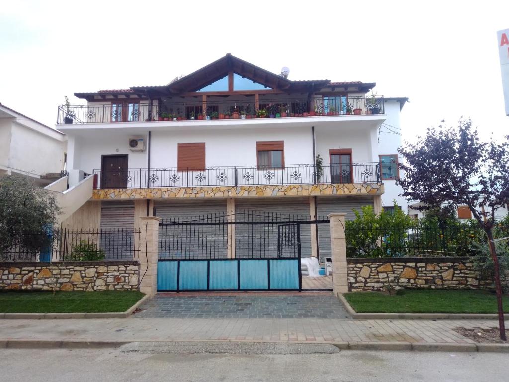 Cette maison blanche dispose d'un balcon avec une porte bleue. dans l'établissement Idili Historik i Kodrës, à Berat