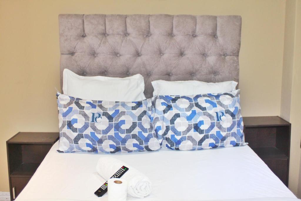 a bed with blue and white pillows and a headboard at Home Stay Accommodation in Cape Town