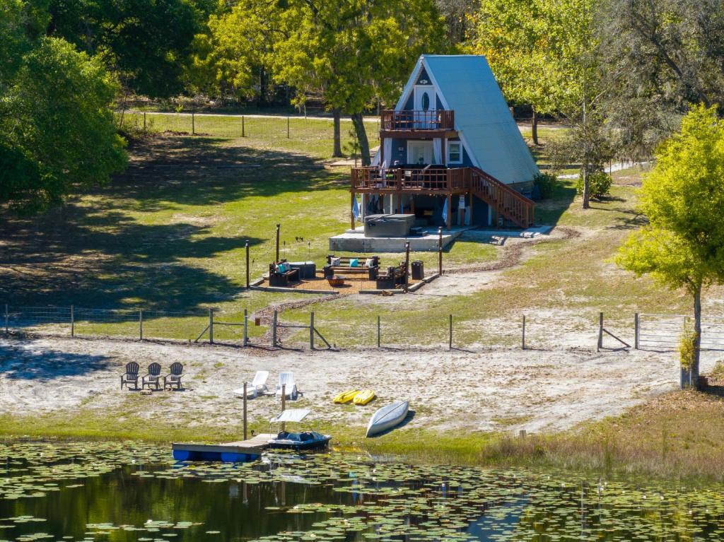 ein Haus mit blauem Dach neben einem See in der Unterkunft Lakefront Escape-Hot Tub-FirePit-Rural Retreat in Melrose