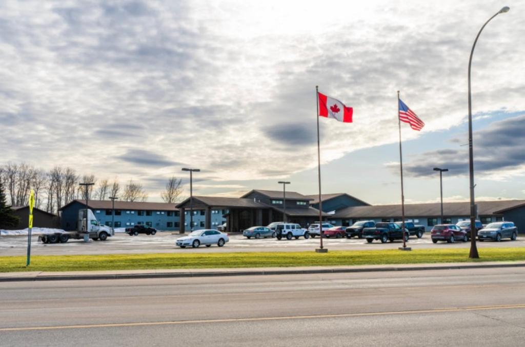 zwei kanadische Flaggen vor einem Parkplatz in der Unterkunft The Patch Lodge in Warroad