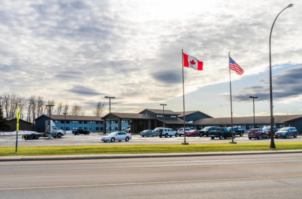 two canadian flags flying in front of a parking lot at The Patch Lodge in Warroad