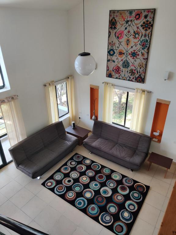 a living room with a couch and a rug at Haven Guest House in Kodaikānāl