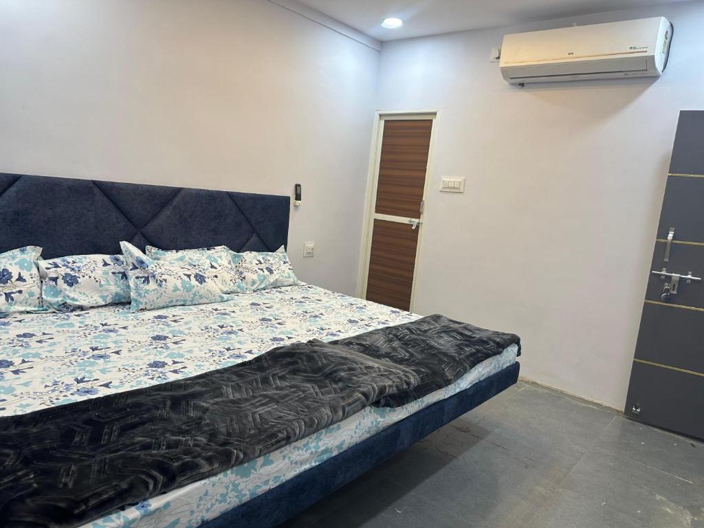 a bedroom with a bed and a air conditioner at Hotel Hakimi in Ujjain