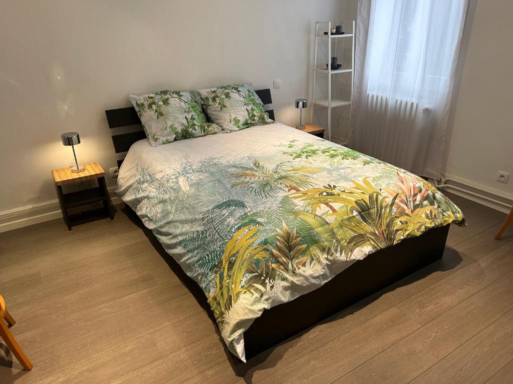 um quarto com uma cama com um edredão colorido em Salutho em Sélestat