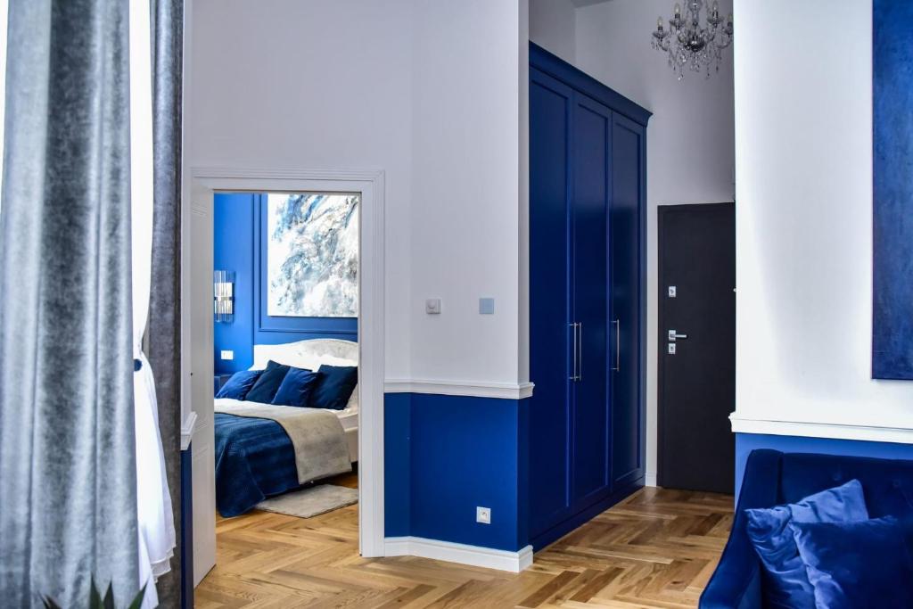 Dormitorio azul con cama y espejo en Supreme Tatarska, en Przemyśl