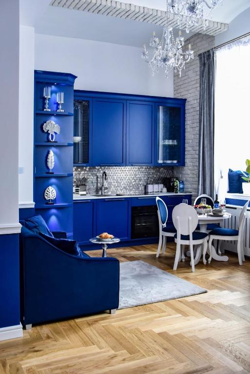a kitchen with blue cabinets and a dining room at Supreme Tatarska in Przemyśl