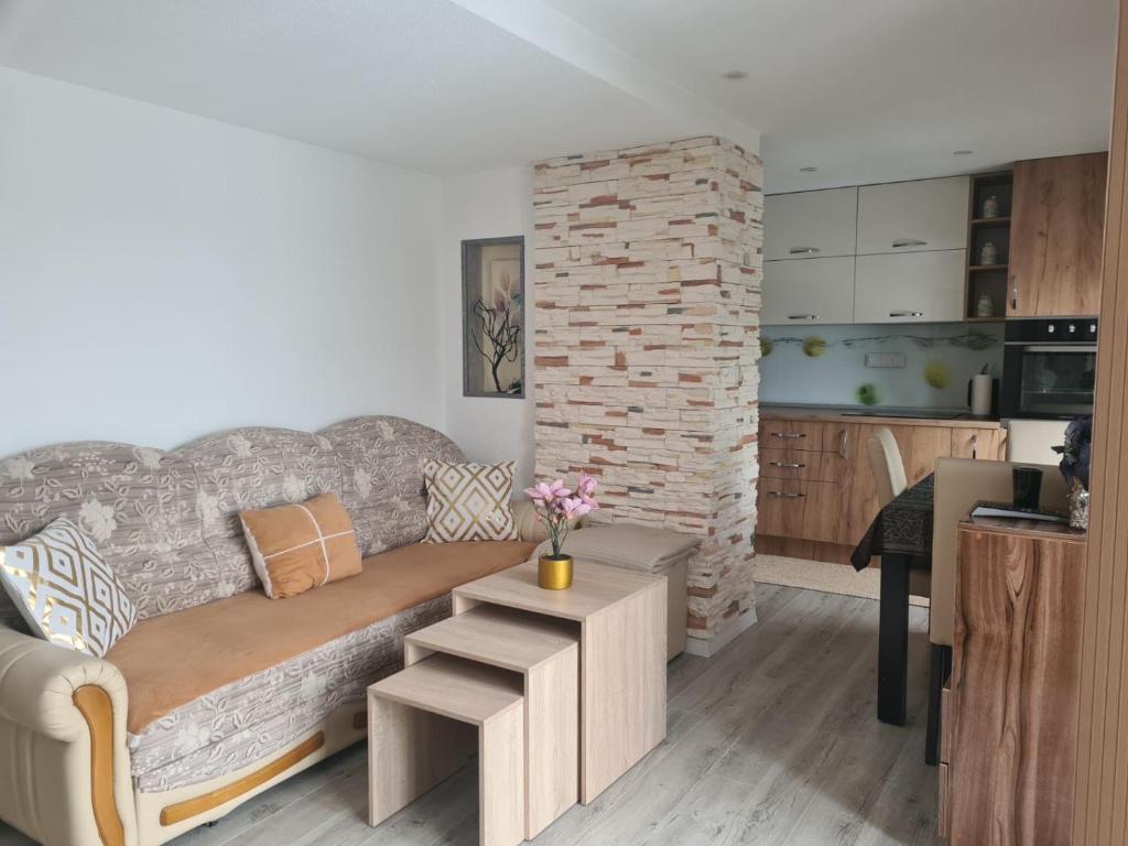 a living room with a couch and a brick wall at Leki Apartman in Travnik