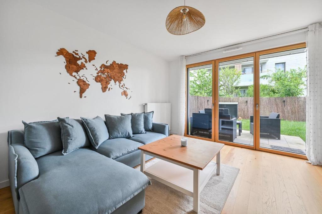 a living room with a blue couch and a table at Le Lumina - 6 pers - Proche Orly - Jardin in Rungis