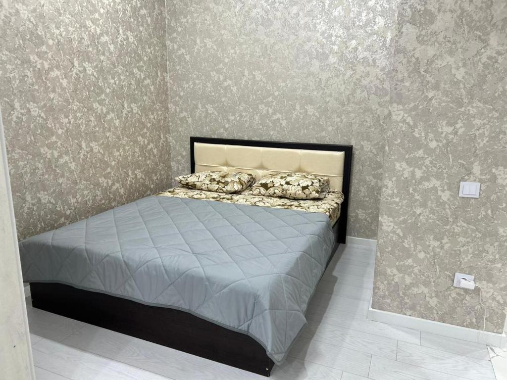 um quarto com uma cama num quarto com papel de parede em Altyn Dala em Taldykolʼ