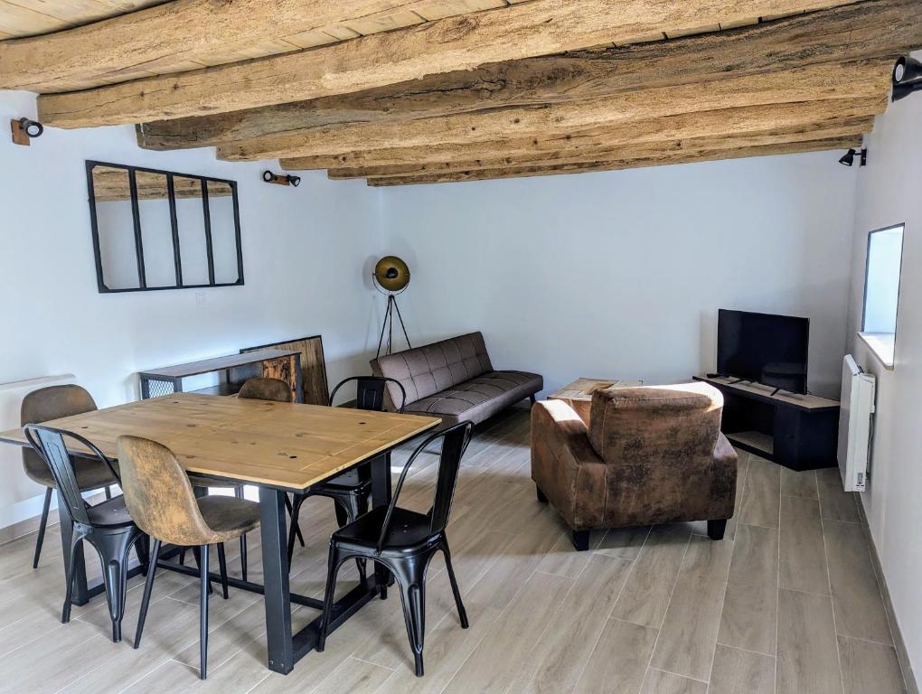 ein Wohnzimmer mit Tisch und Stühlen und einer Couch in der Unterkunft Charmante maison 6 pers, proche Loire à vélo in Suèvres