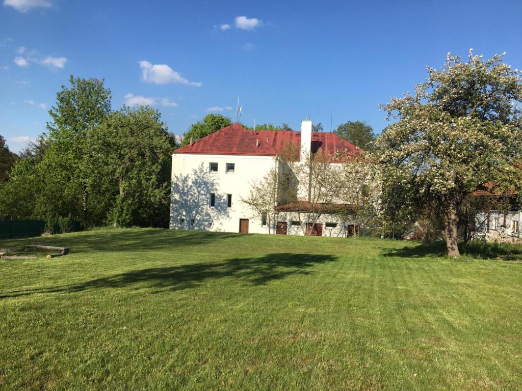 une maison avec une cour herbeuse devant un bâtiment dans l'établissement Budova U dvojice, à Nové Město na Moravě