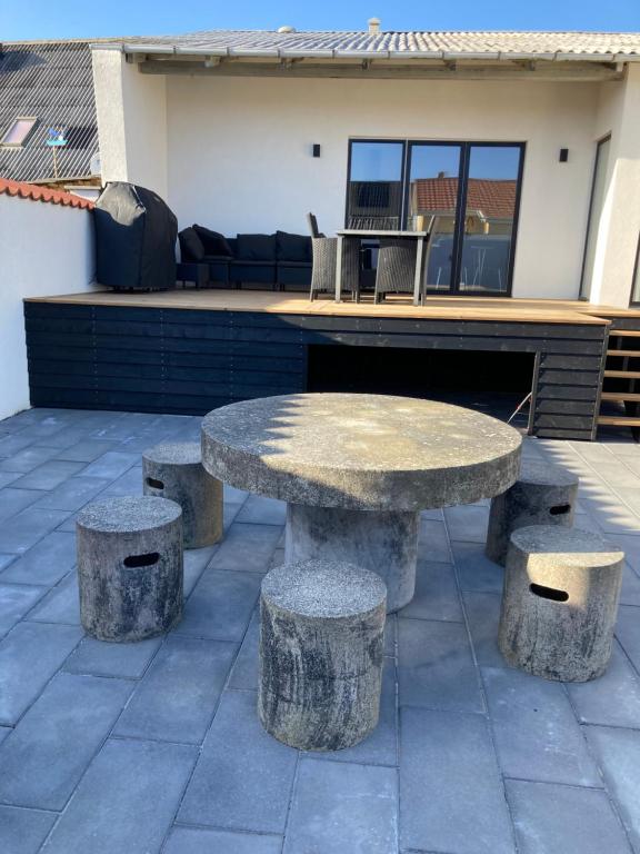 a stone table and stools on a patio at Poppel alle 2 b Hirtshals in Hirtshals