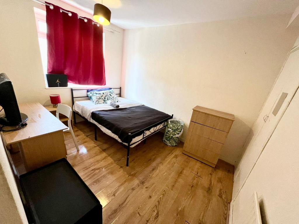 a small room with a bed and a red window at Close to Central London in London