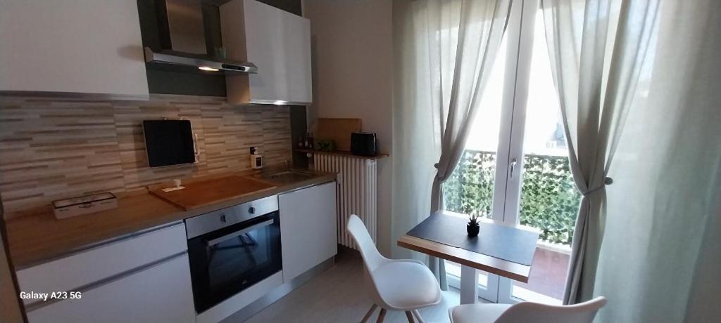 une cuisine avec un comptoir, une table et une fenêtre dans l'établissement Little Sweet Home - Fiera Milano, à Pero