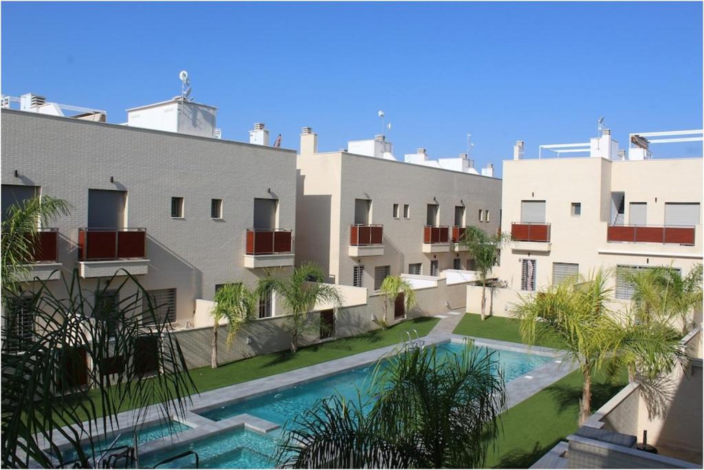 an apartment building with a swimming pool in front of it at Trendy and Modern New Built 2 Bedroom Apartment close to the Beach in Torre de la Horadada
