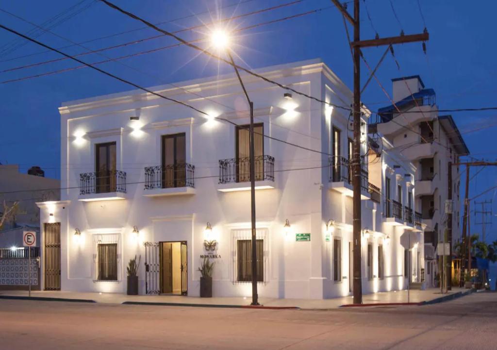 a white building with a street light in front of it at Departamentos & Villa Monarka, 1 Block from Malecon! in La Paz