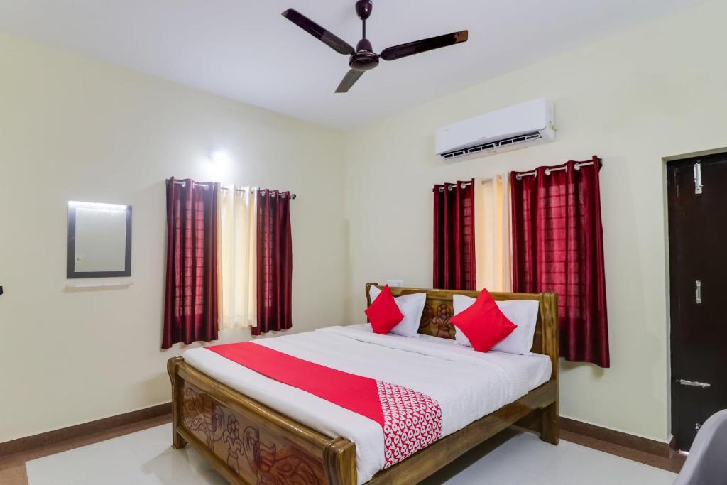 a bedroom with a bed with red pillows at OYO Flagship Hotel Vaiko in Khandagiri