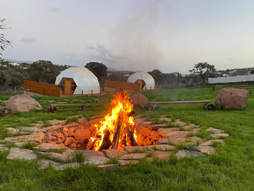 a fire pit in a field with tents in the background at Bodrum Dome Suites in Bodrum City