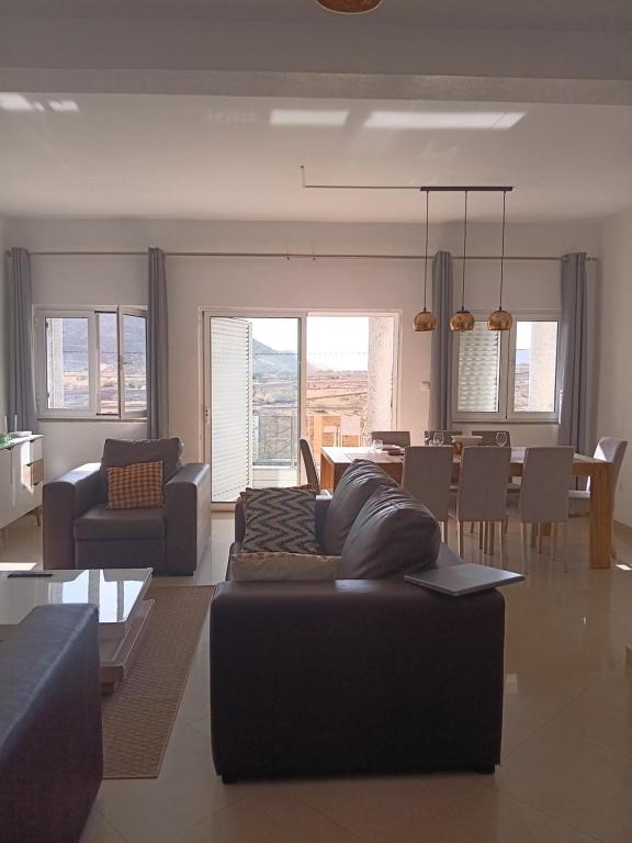 a living room with a couch and a dining room at Cosy 3 bedroom apartment calm and landscape view in Praia