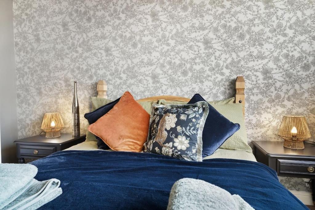 um quarto com uma cama com lençóis e almofadas azuis em The Beacon, apartment next to the seafront in Herne Bay em Kent